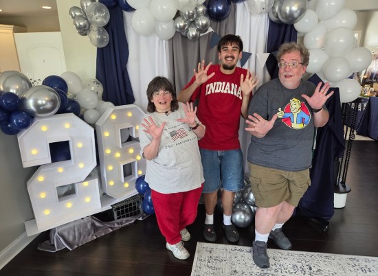 Us doing jazz hands with our nephew at his party, Class of 2026.