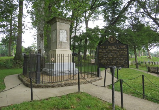 Daniel Boone grave surrounded by black iron fence, historical marker standing outside it.