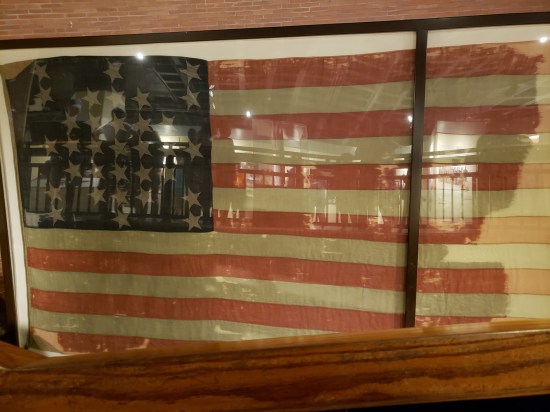 Battered 1861-era American flag in a display case.
