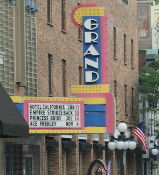 Grand Theatre marquee with coming attractions Hotel California, The Empire Strikes Back, The Princess Bride, and Ace Frehley.
