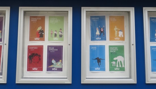 Eight stylized, modern-day posters for old movies being shown at the theater.