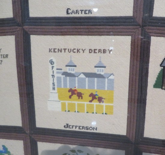 Quilt art of a horse race's finish line.