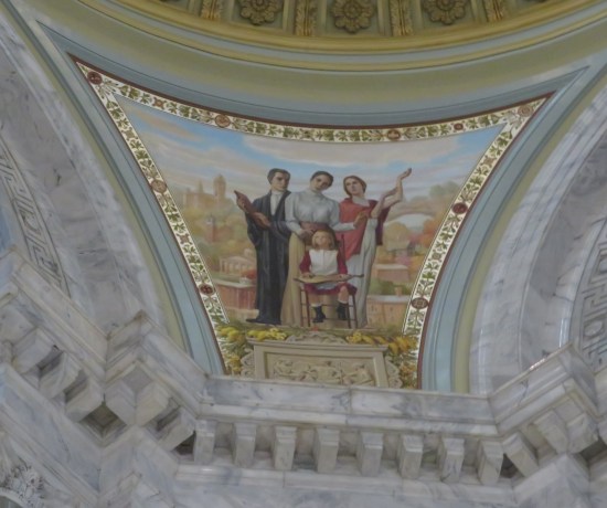 Triangular ceiling art of a pioneer woman, a young judge, a Greek muse, and a sitting pioneer girl with some wooden gizmo in her lap.