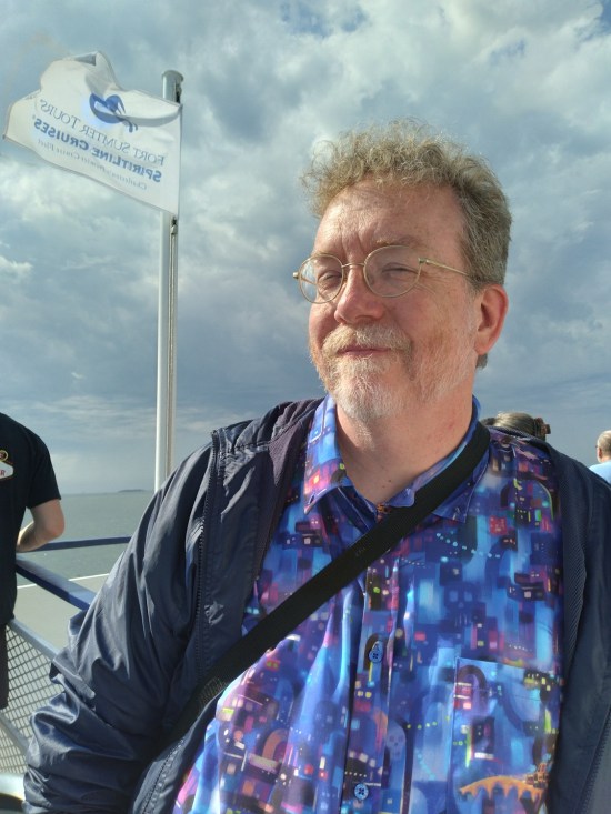 me on a boat wearing a light rain jacket. The white Fort Sumter Ferry Tours flag flies above me.