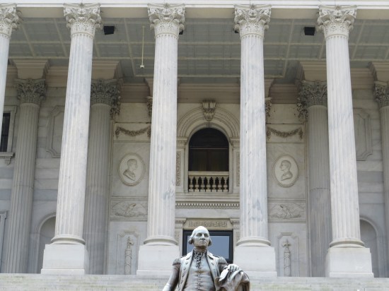 State capitol front columns and foor. At bottom is the top half of a Washington statue farther down the front steps.
