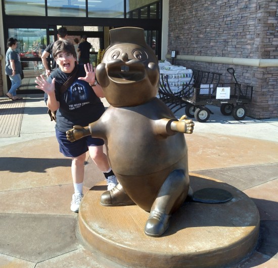 Anne doing jazz hands next to an unlabeled Buc-ee statue.