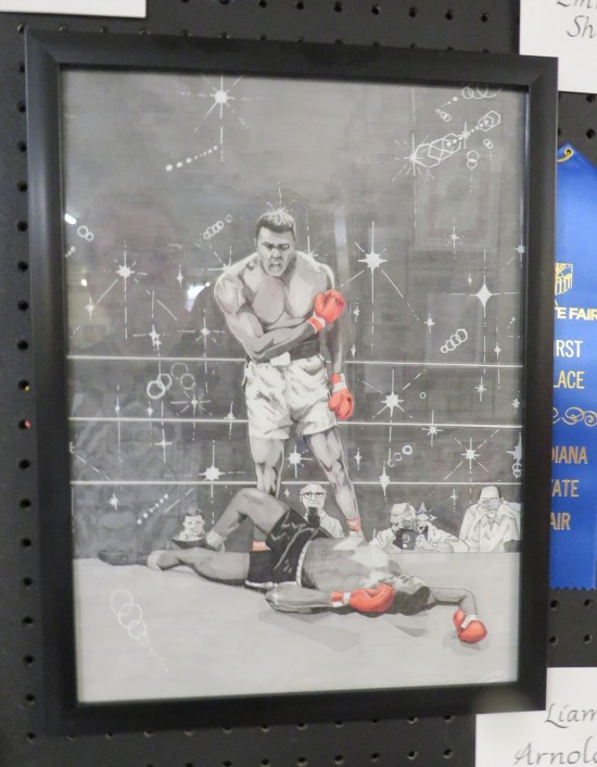 Black-and-white drawing of Muhammad Ali standing over a defeated opponent in the ring. Only their gloves are red.
