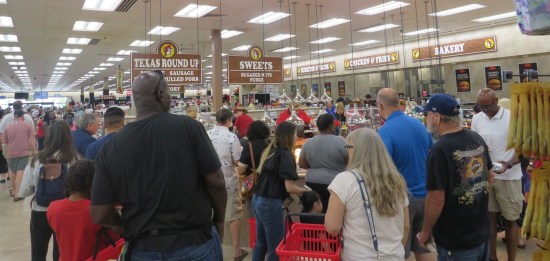 Crowd inside a Buc-ee's. Food stations include bakery, chicken and fries, burritos and tacos, sweets, and Texas Round-Up.