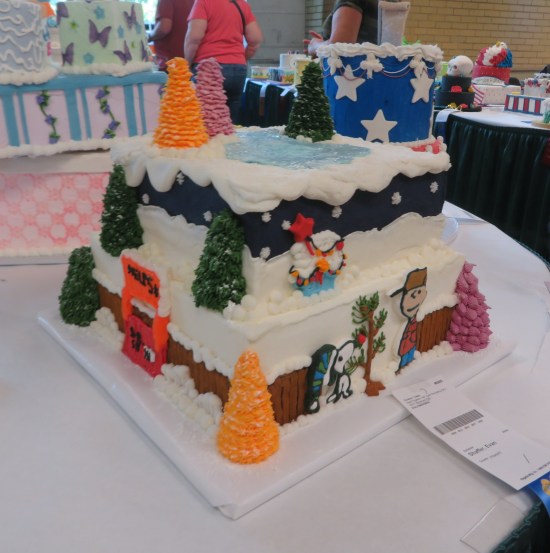 Cake with Charles Schulz art on the sides and an ice skating rink on top.
