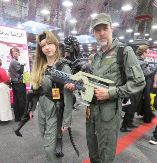 Colonial Marines from the Aliens movies, one with a xenomorph puppet riding on her back.
