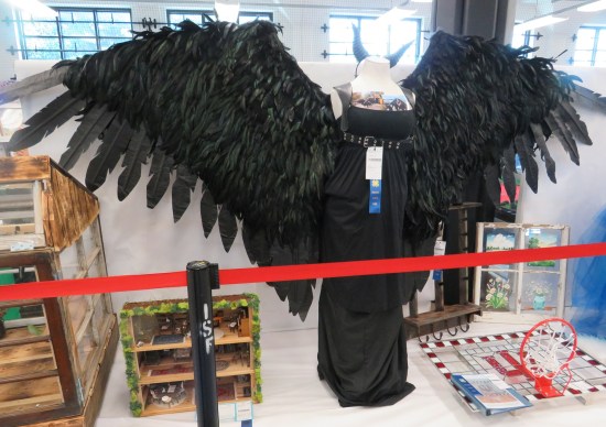 black dress with giant cosplay wings extended from the back.