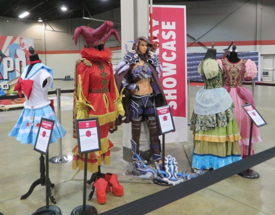 Costumes displayed in the middle of a mostly empty convention center hall.