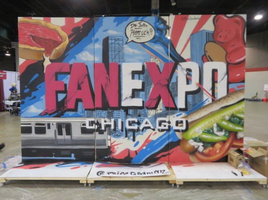 Indoor mural on freestanding wooden wall with Fan Expo Chicago logo and familiar Chicago sights in the background.
