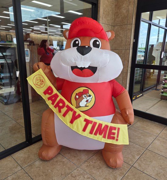 inflatable Buc-ee with a yellow sash reading "party time!"