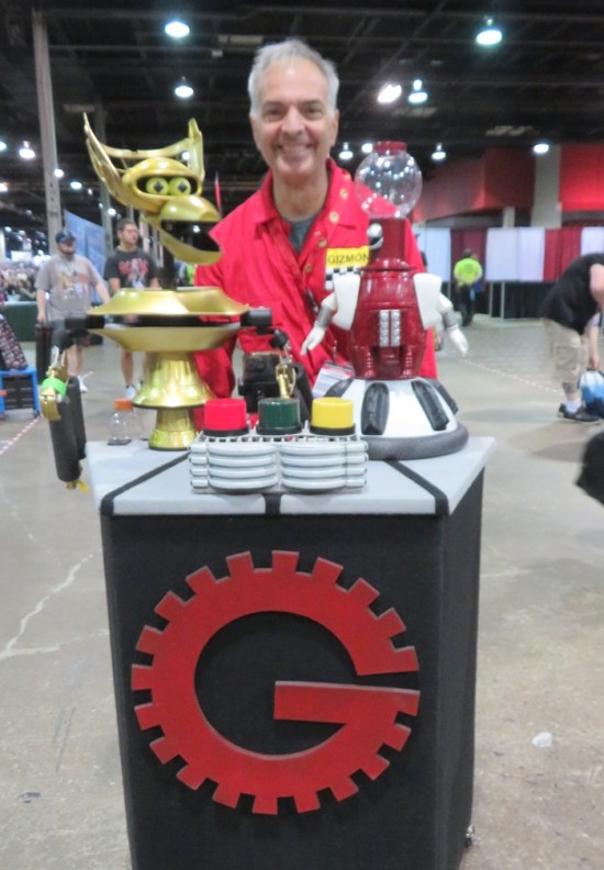 Joel Robinson cosplayer pushing around a Gizmonic podium with Tom Servo and Crow bots on it.