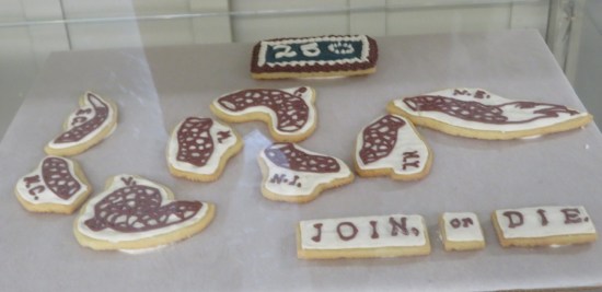 A dozen cookies shaped like Benjamin Franklin's famous "Join or Die" political cartoon.