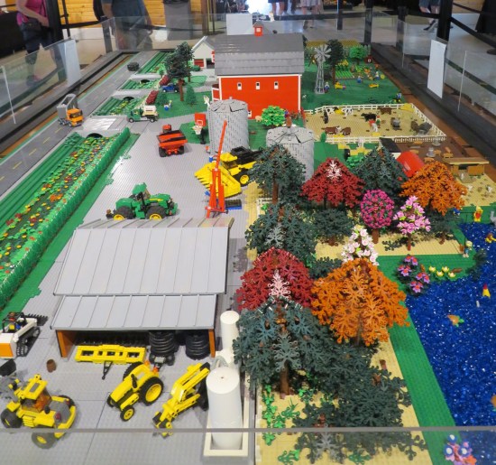 entire large table covered in farm-themed Lego sets and vehicles.
