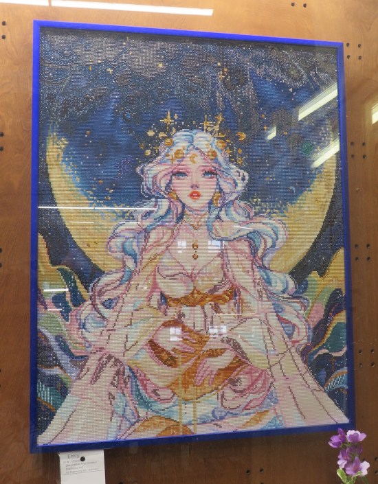 Picture of anime goddess at nighttime, made of tiny diamond-shaped plastic pieces or something.