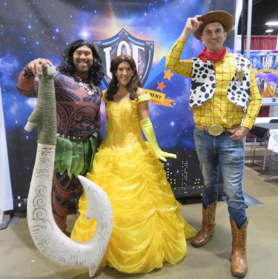 Disney cosplayers as Maui from "Moana", Belle in her ballroom dress, and Sheriff Woody!