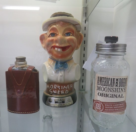 A booze flask, a moonshine jar, and a Mortimer Snerd whiskey bottle.
