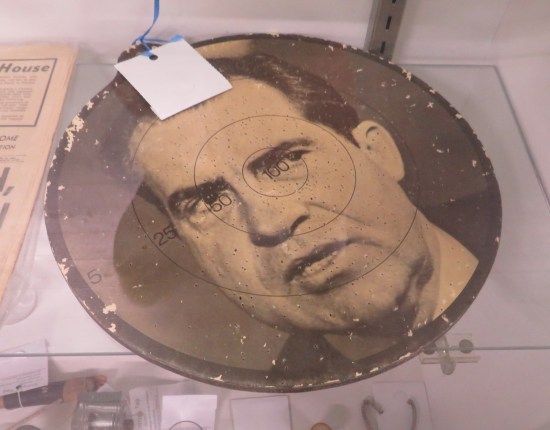 Old dartboard covered with black-and-white photo of Nixon's face.