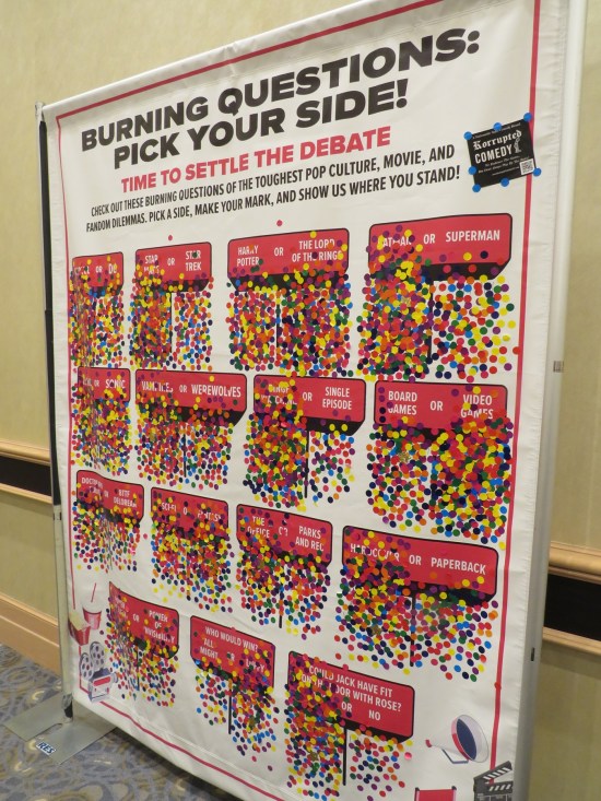 Large wall poster with squares listing various binary fan debates, where we could place stickers on the side we chose.