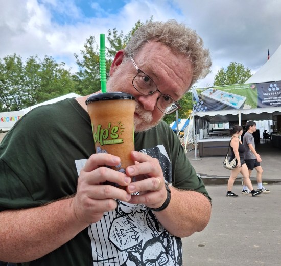 Me happily holding a plastic bottle filled with brownish liquid.