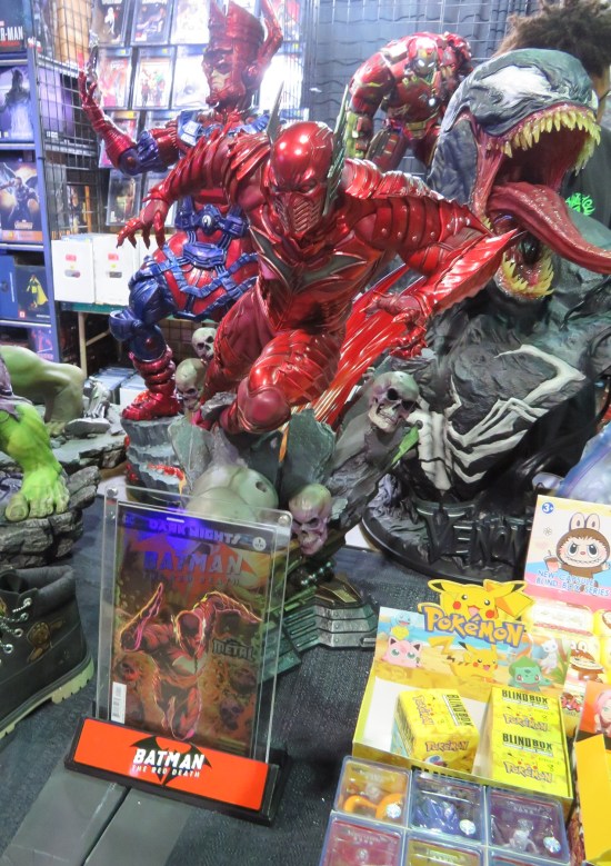 Statue of villain in red metal segmented armor.