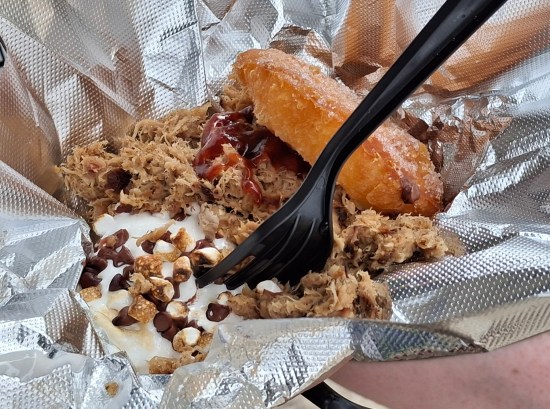 lots of pulled pork on a fried biscuit with barbecue sauce. Off to one side in the same dish is a melted pool of marshmallows and chocolate chips.