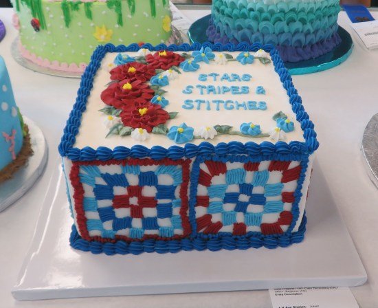 red white and blue cake with lattices on the sides. Top says "Stars Stripes & Stitches".