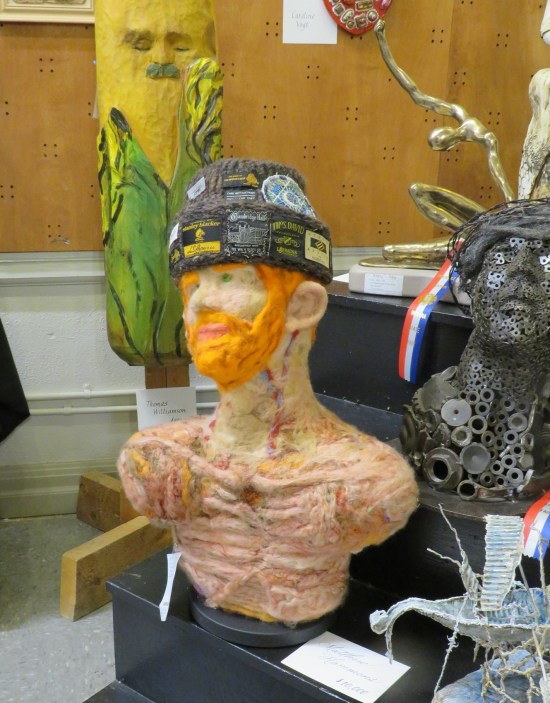 Sculpture of torso of starving, red-bearded man wearing a stocking cap but no shirt