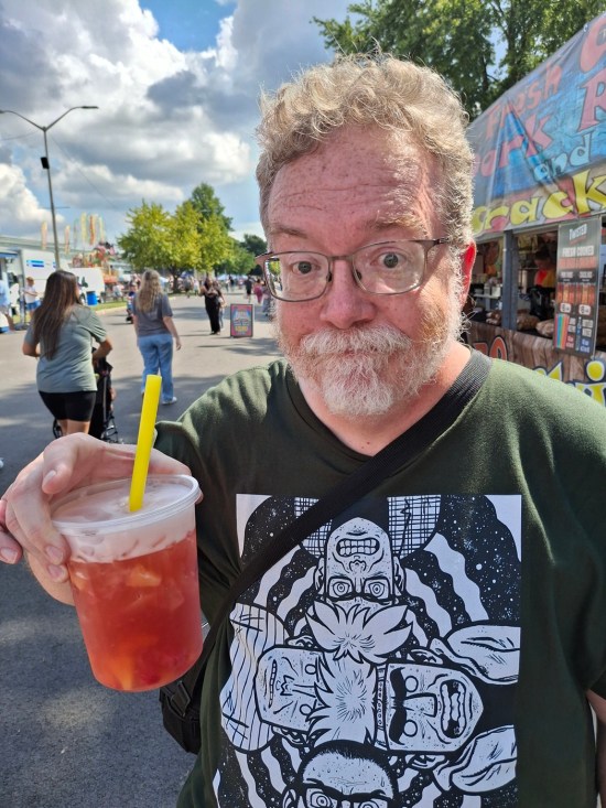 Me smiling with a red drink with fruits in it.