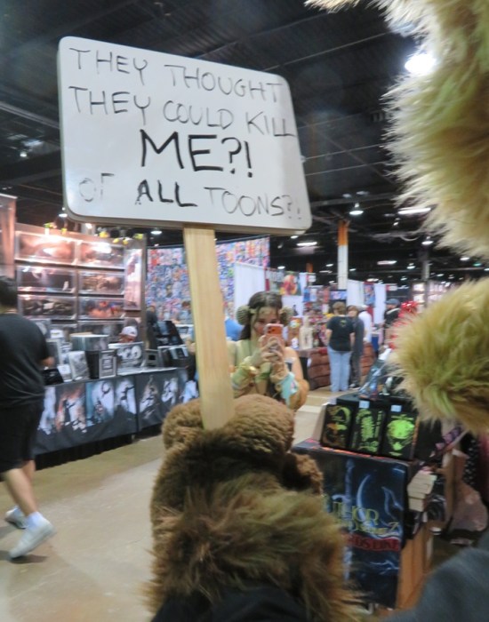 Back of Wile E Coyote cosplayer's sign reads "They thought they could kill ME? Of all toons?"
