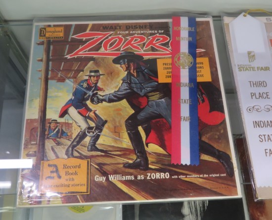 Four Adventures of Zorro record and book with cover painting of our hero played by Guy Williams, sword-fighting an evil soldier.