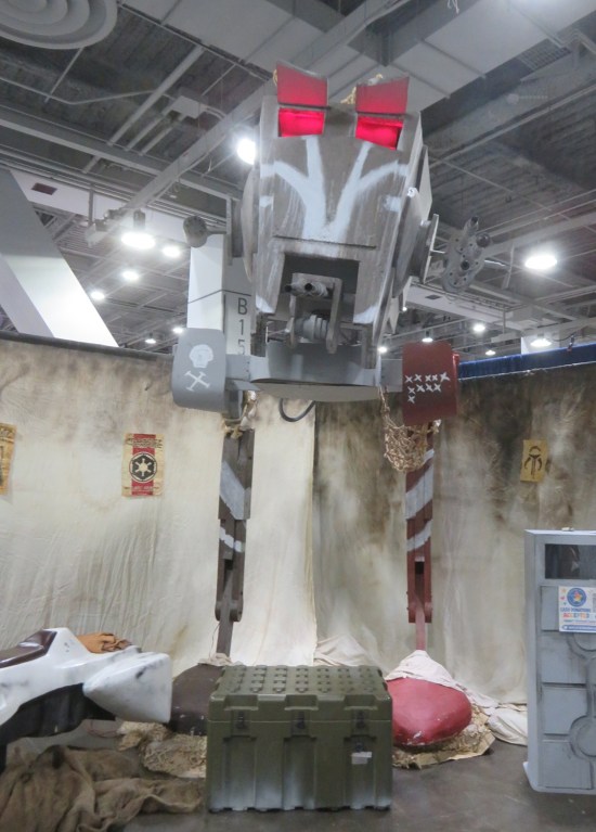 Tall AT-ST model in a comic-con booth.