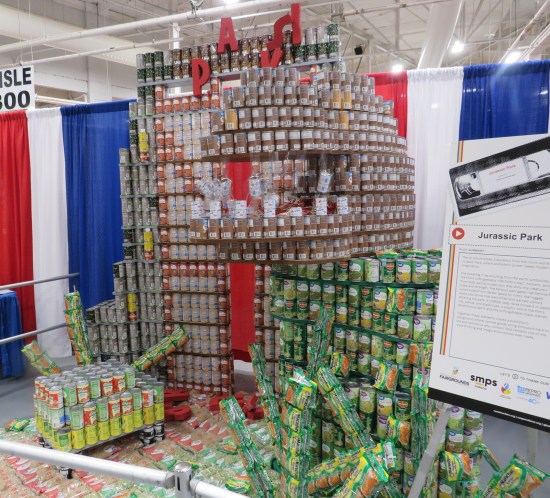 Canned Jurassic Park with T-Rex and broken park logo.