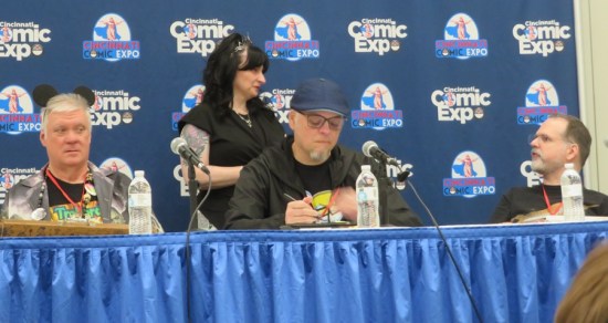 Three artists and a moderator standing behind them.