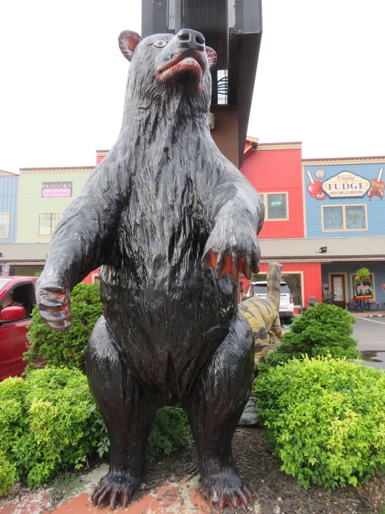 bear statue outside, set under a tall store sign.