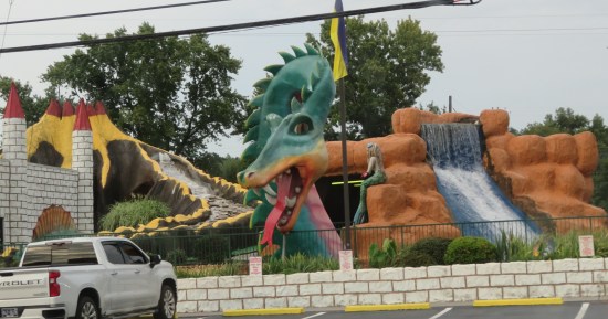 dragon and mermaid statues at a water park, at least two visible waterfalls.
