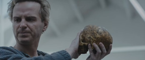 Andrew Scott does Hamlet's graveyard scene, holding Yorick's skull but turning away from it.