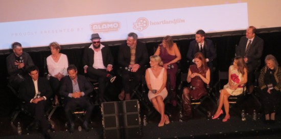 Black stage with 13 people seated in two rows.