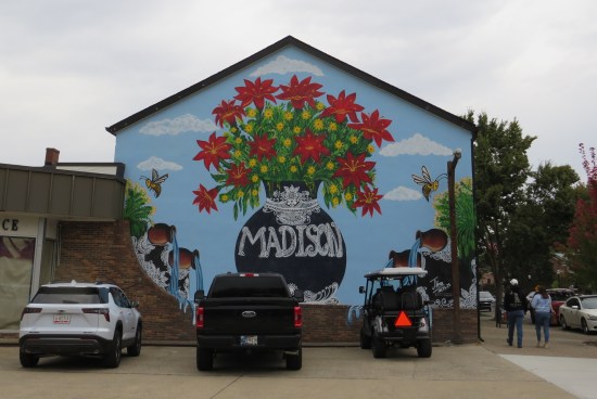 Side of a two-story building with pic of blooming flowerpot with MADISON written on it.