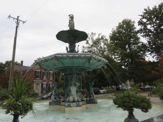 Large copper fountain surrounded by spitting mermen and with a warrior woman on top.