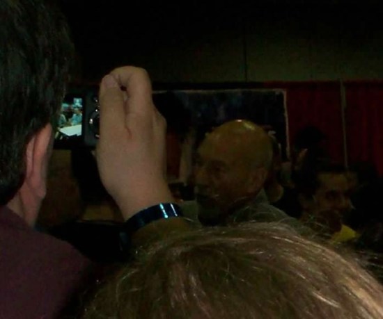 Some guy with an old digital camera snapping Patrick Stewart in a poorly lit crowd.